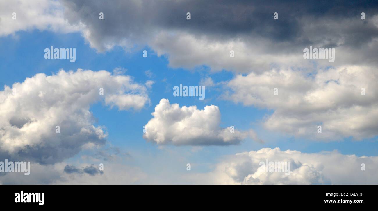 Weiße Cumulus Wolken zwischen dunklen Regenwolken, natürlicher Himmel Hintergrund Stockfoto