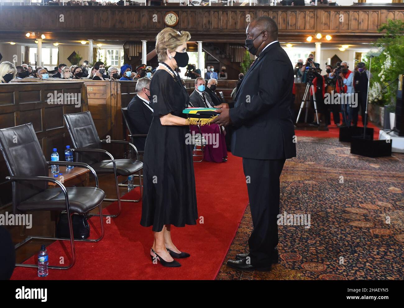 (211212) -- KAPSTADT, 12. Dezember 2021 (Xinhua) -- Der südafrikanische Präsident Cyril Ramaphosa (R, Front) überreicht Elita de Klerk, der Ehefrau von Südafrikas letztem Apartheid-Präsidenten Frederik Willem (FW) de Klerk, während des staatlichen Gedenkgottesdienstes von de Klerk in Kapstadt, Südafrika, am 12. Dezember 2021 eine südafrikanische Nationalflagge. Der südafrikanische Präsident Cyril Ramaphosa erkannte am Sonntag die wichtige Rolle des letzten Apartheid-Präsidenten Frederik Willem (FW) de Klerk beim demokratischen Wandel des Landes an und gab zu, dass das Erbe des ehemaligen Präsidenten während seiner staatlichen Gedenkfeier weiterhin „umstritten“ ist Stockfoto