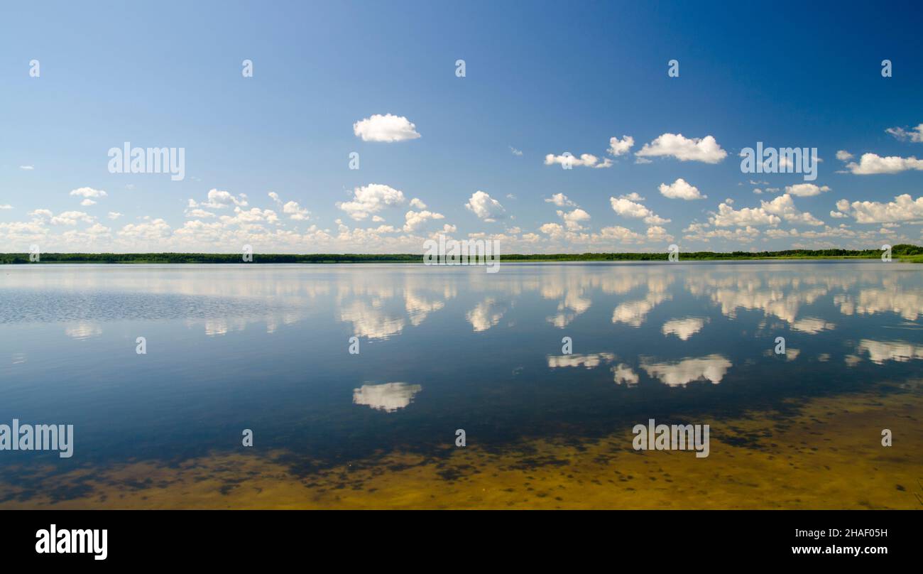 Wolken spiegeln sich in reinem Seewasser, herrlicher Himmel und Wolken über dem Spiegelbild des Seewasserpanoramas Stockfoto