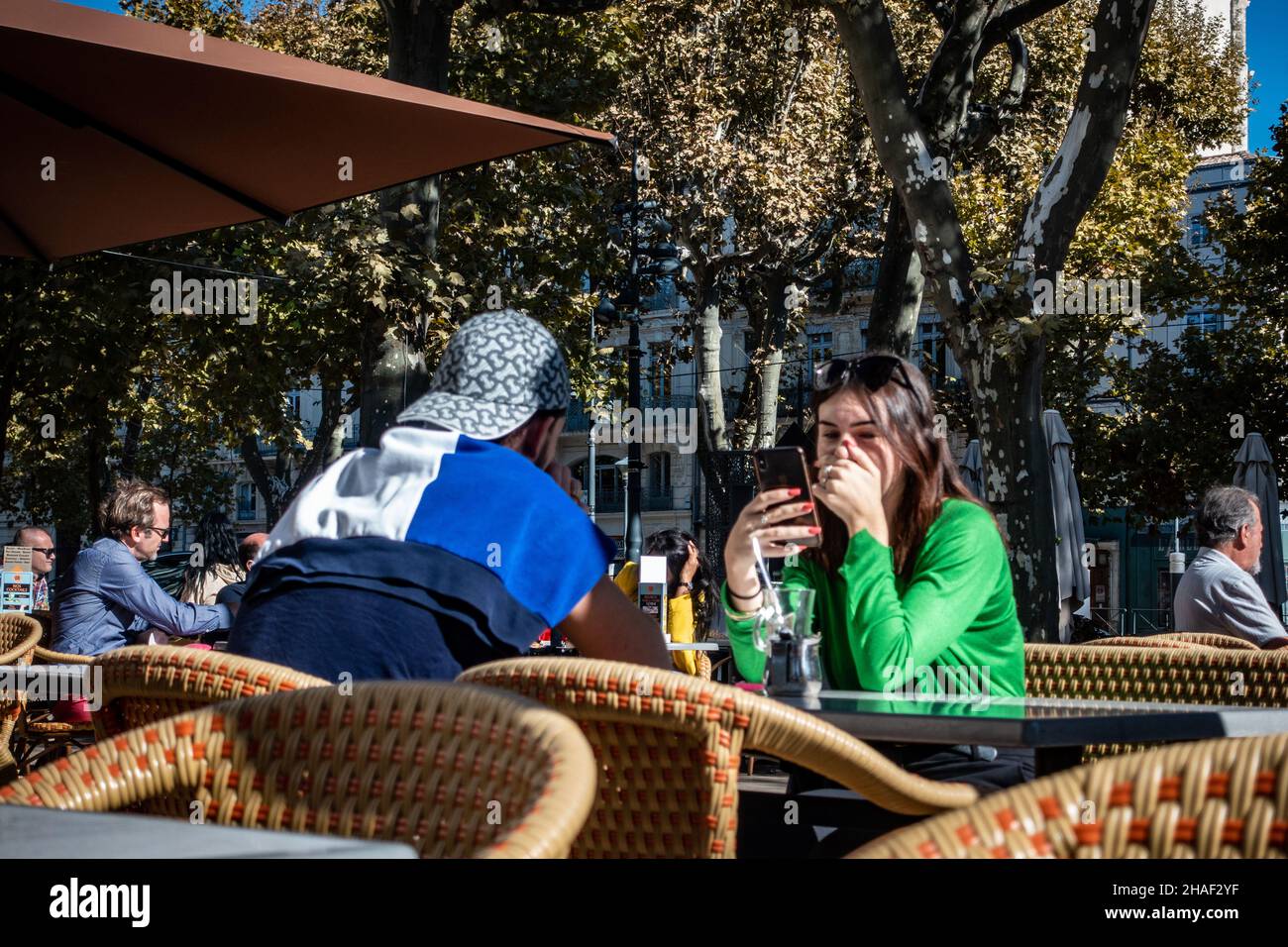 Ein junges Paar, das draußen in einem französischen Straßencafé sitzt Stockfoto