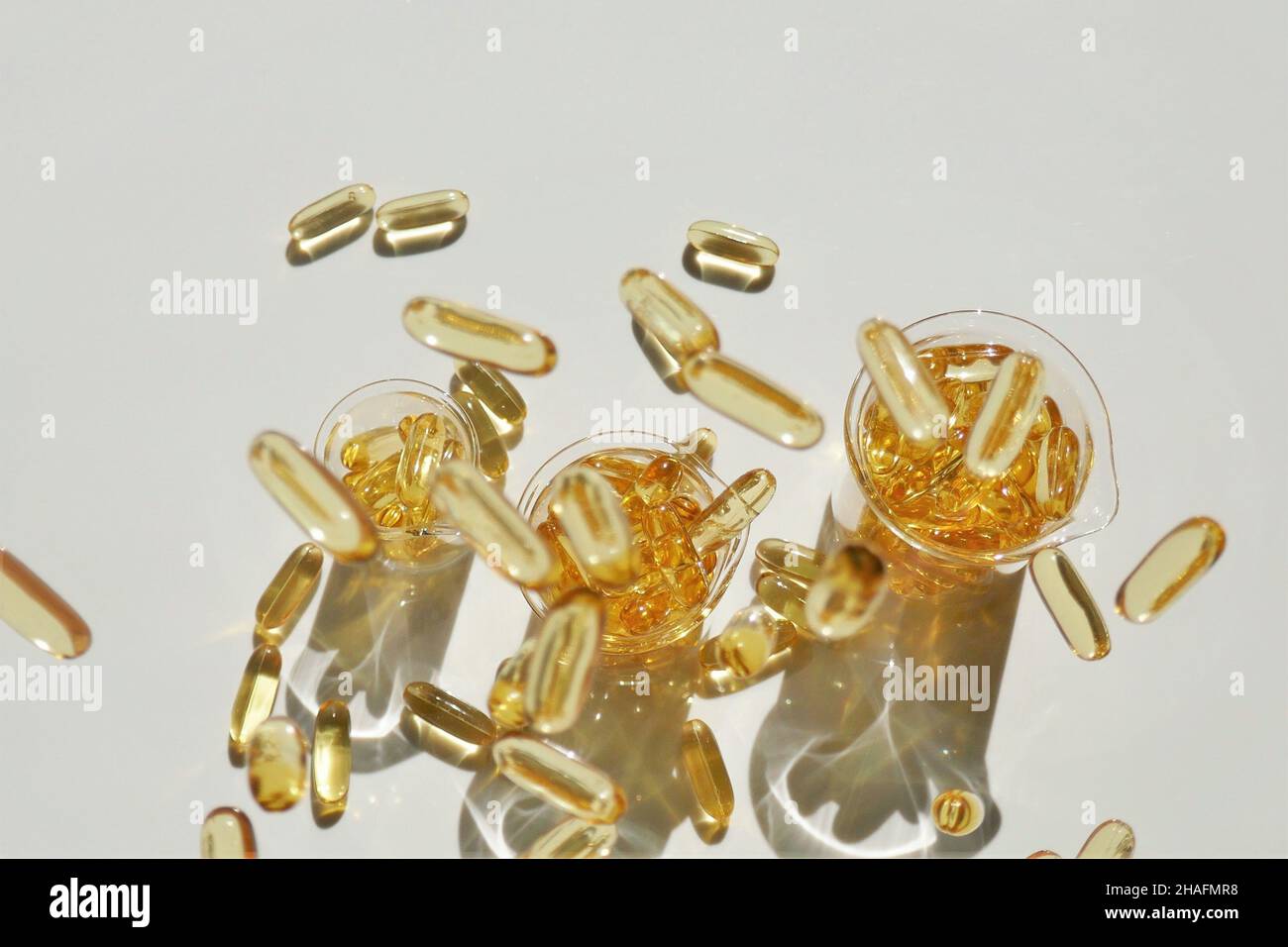 Fischöl-Gelatinekapseln in Laborflaschen auf weißem Hintergrund.Fliegende Kapseln Fischöl.Omega-Fettsäuren.natürliche Nahrungsergänzungsmittel Stockfoto