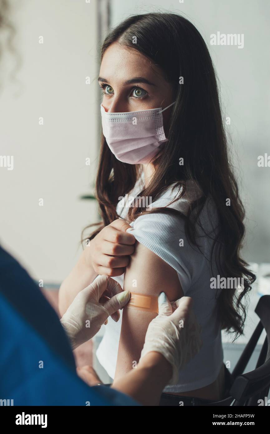 Arzt, der nach der Injektionsimpfung einen Pflaster-Verband auf einen Patientenarm legt. Impfungen für Erwachsene, Covid-Impfstoff. Gesundheitswesen, Coronavirus. Gesund Stockfoto