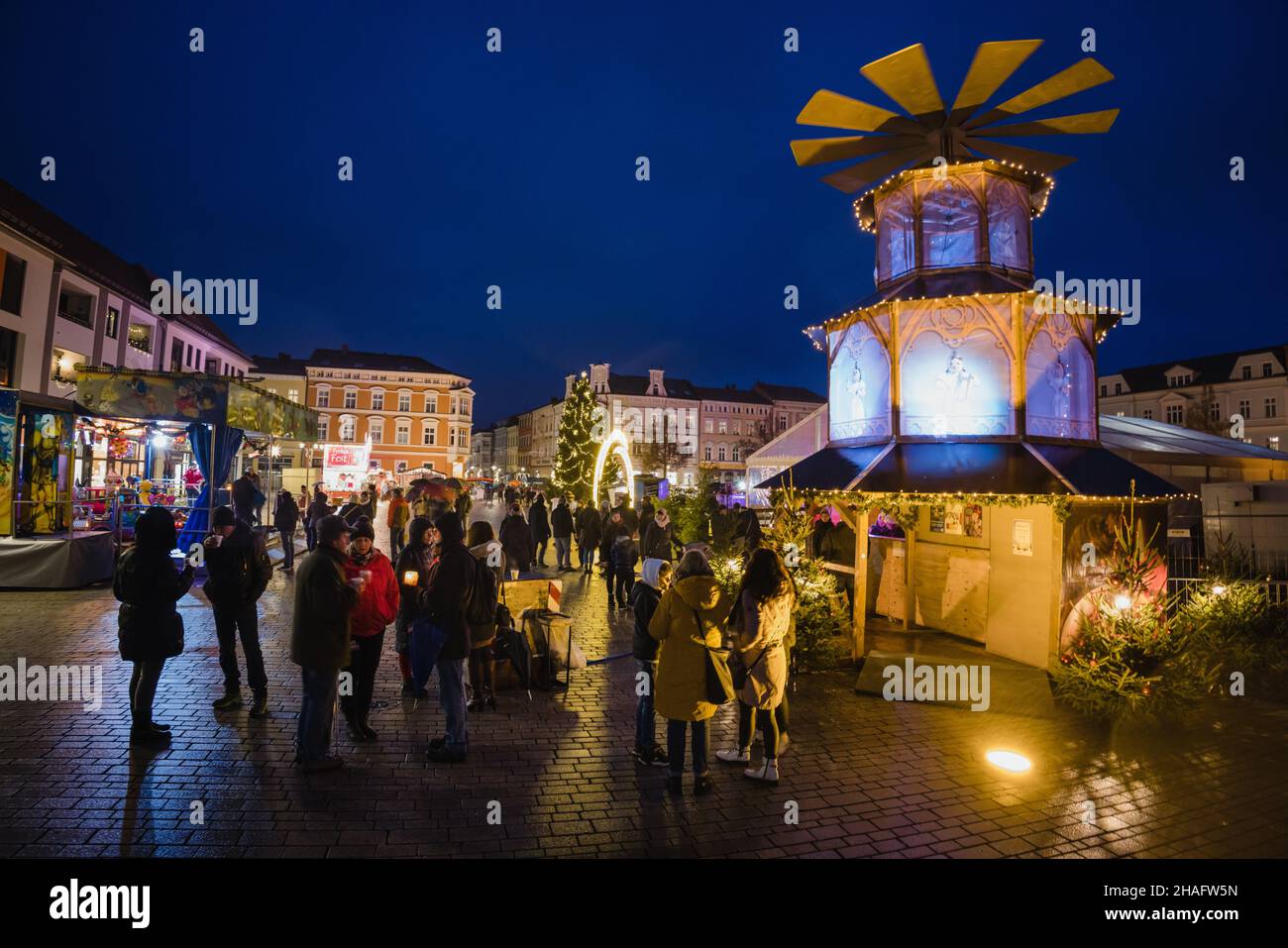 Meiningen, Deutschland. 12th Dez 2021. Die Menschen stehen um einen Glühweinstand, der als Weihnachtspyramide auf dem Markt umgebaut wurde. Nachdem der MEININGER Weihnachtszauber wegen Korona erneut abgesagt wurde, bildet die MEININGER Straßenweihnacht mit weit und breit über den Markt verteilten Hütten mit weihnachtlichen Angeboten einen regelkonformen Ersatz. Quelle: Michael Reichel/dpa/Alamy Live News Stockfoto