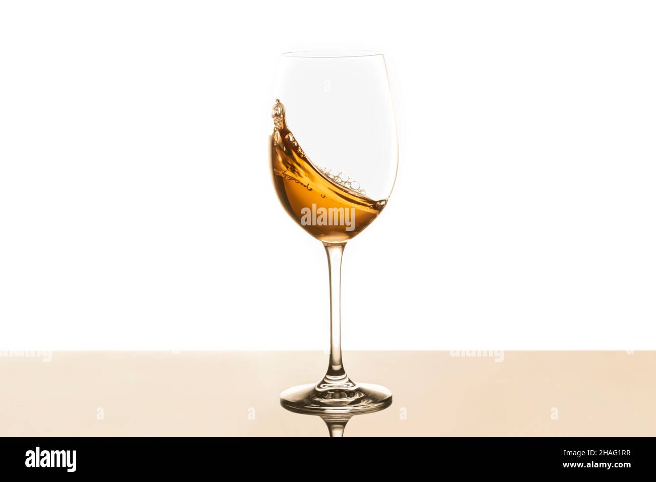 Weißwein, der in Glas wirbelt. Selektiver Fokus Stockfoto