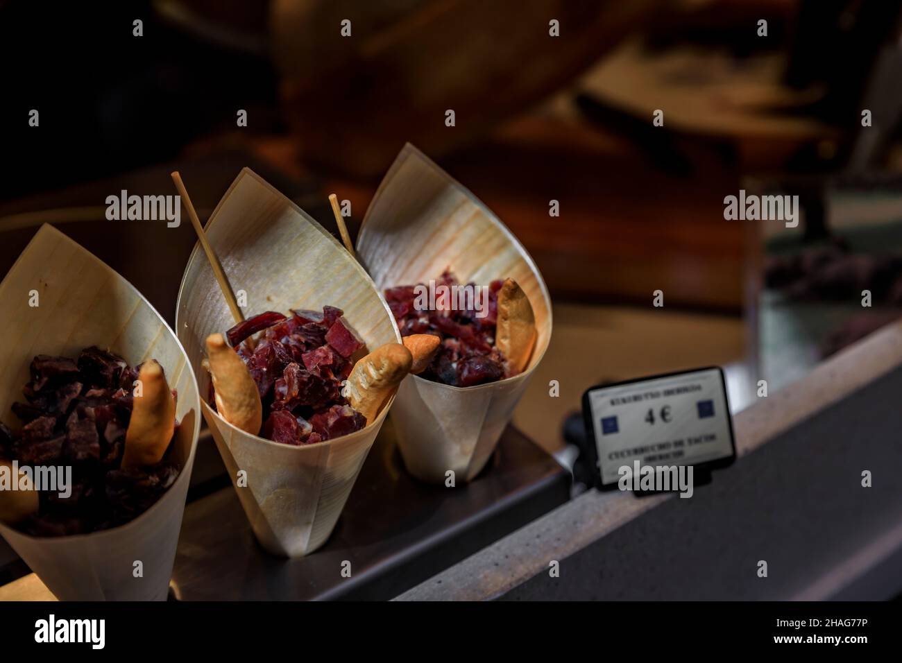 Zapfen von Cucurucho Pintxos oder Tapas mit spanischem serrano-Iberico-Schinken und Brotscheiben in einer Metzgerei in San Sebastian, Baskenland, Spanien Stockfoto