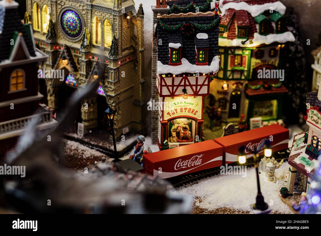 Minsk, Weißrussland, Dezember 2021 - Miniaturmodell eines Bahnhofs und Zuges mit dem Coca Cola Logo. Enges Fokusfeld. Weihnachtszeit Stockfoto