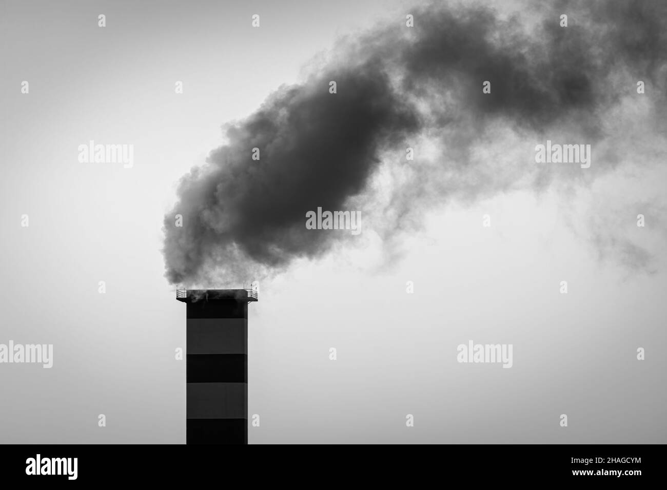 Kamin im Heizraum, aus dem Rauch vor dem Hintergrund des Himmels austicht. Stockfoto