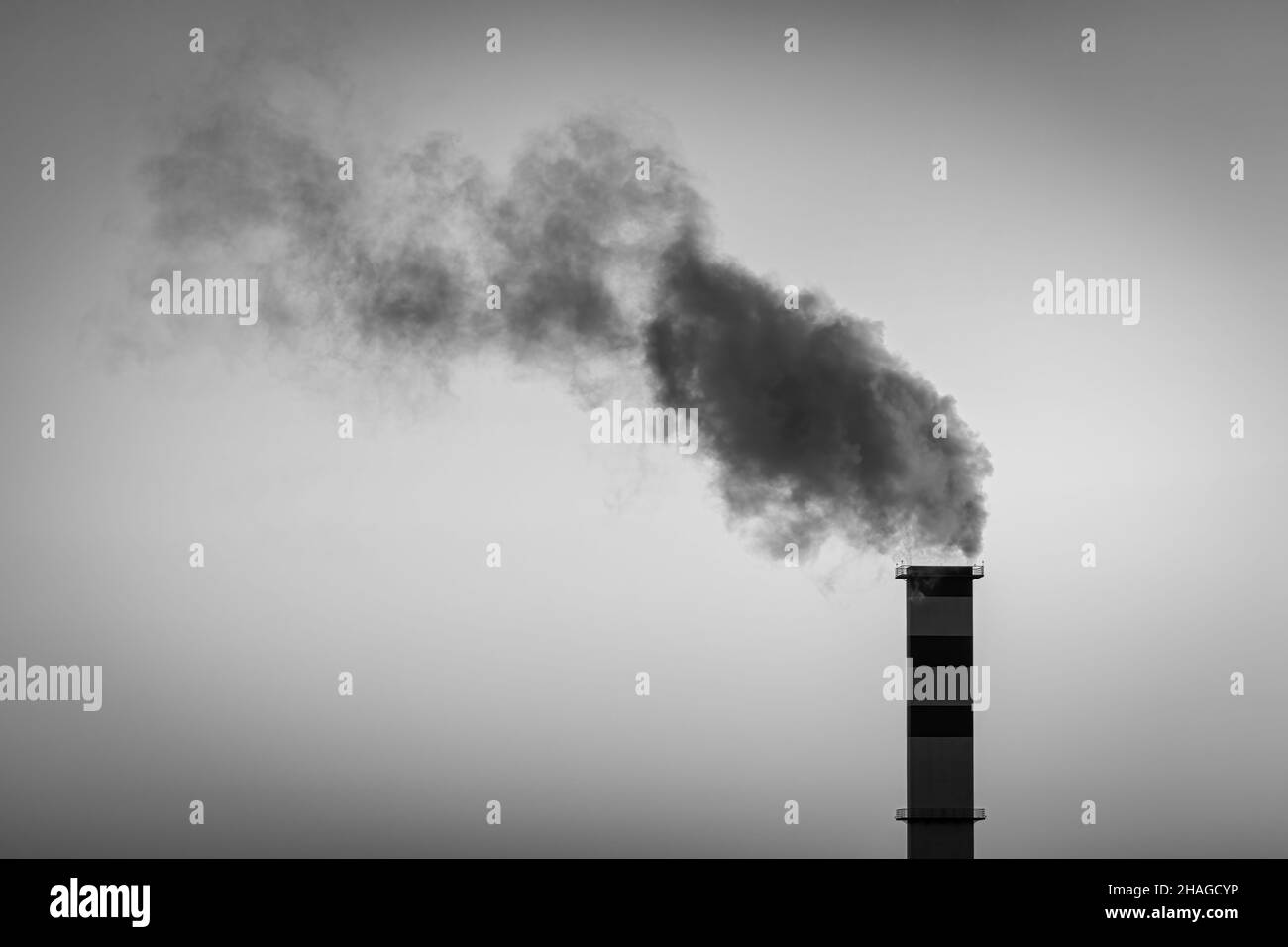 Kamin im Heizraum, aus dem Rauch vor dem Hintergrund des Himmels austicht. Stockfoto