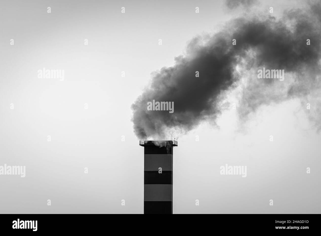Kamin im Heizraum, aus dem Rauch vor dem Hintergrund des Himmels austicht. Stockfoto
