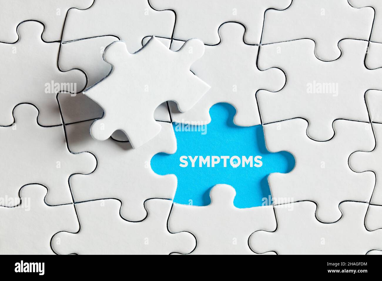 Um die zugrunde liegenden Symptome eines Krankheitskonzepts aufzudecken oder zu entdecken. Das Wort Symptome auf blau fehlende Puzzleteil. Stockfoto
