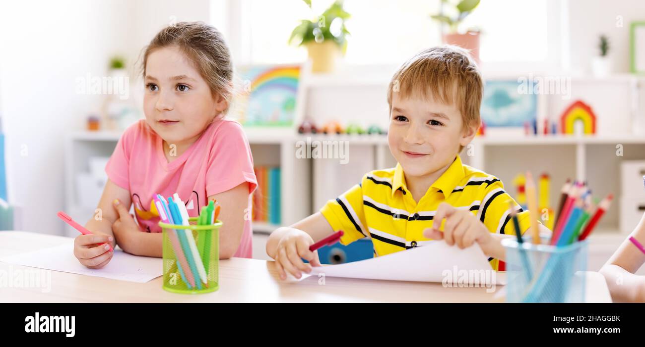 SchuleKinder im Klassenzimmer sitzen an den Tischen und hören sich mit Interesse eine Lektion an. Stockfoto