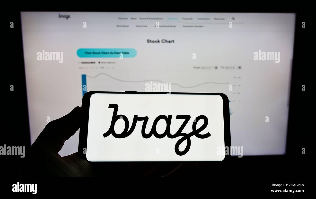 Person, die ein Mobiltelefon mit dem Logo des US-amerikanischen Marketing-Software-Unternehmens Braze Inc. Auf dem Bildschirm vor der Unternehmenswebseite hält. Konzentrieren Sie sich auf die Telefonanzeige. Stockfoto