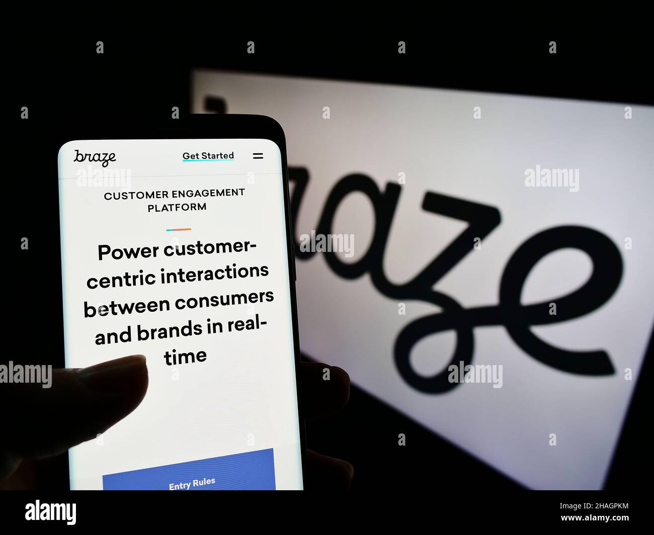 Person, die Mobiltelefon mit der Webseite des US-amerikanischen Marketing-Software-Unternehmens Braze Inc. Auf dem Bildschirm vor dem Logo hält. Konzentrieren Sie sich auf die Mitte des Telefondisplays. Stockfoto
