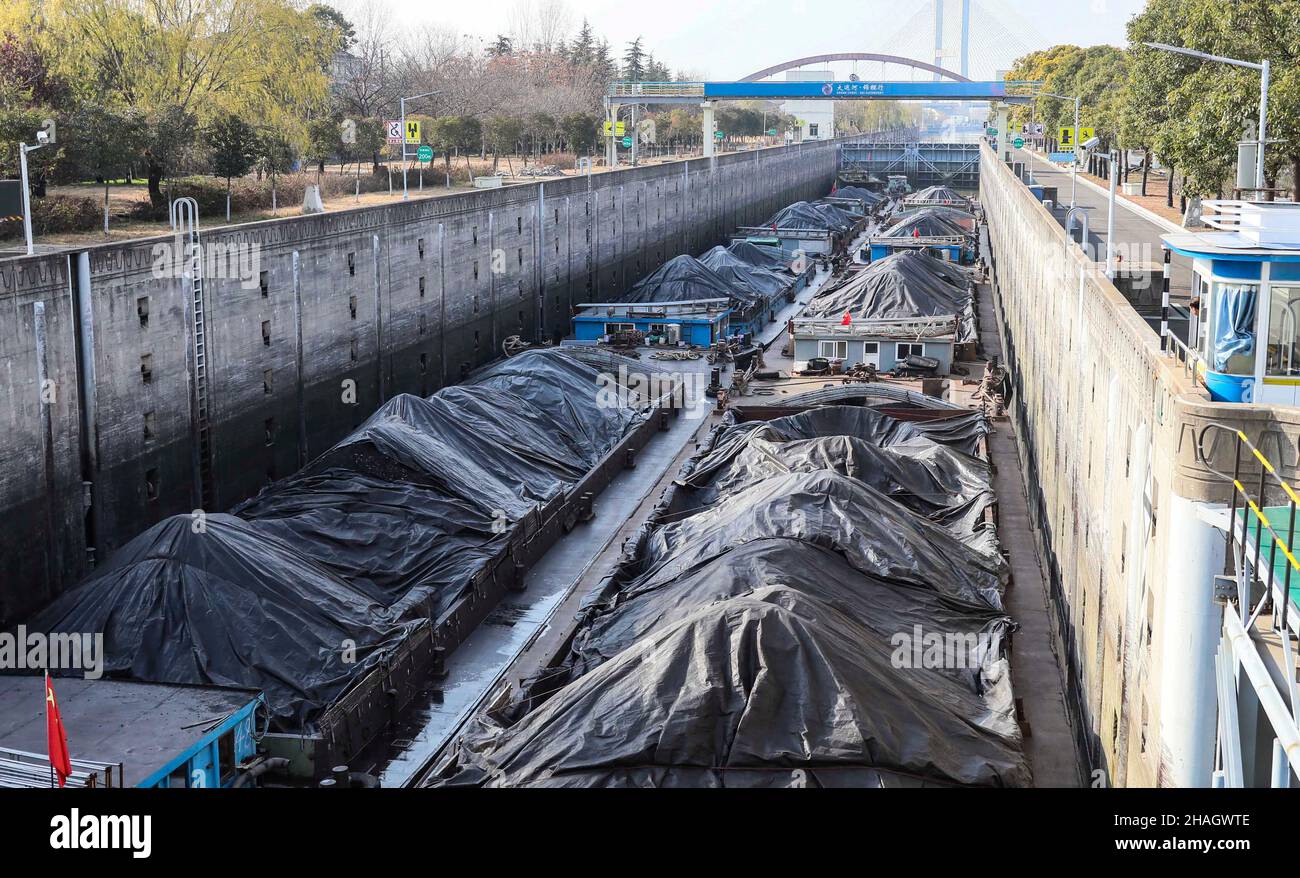 HUAIAN, CHINA - 13. DEZEMBER 2021 - Eine Flotte von Schiffen, die Kohle transportieren, durchquert die Huaiyin-Schleuse des Peking-Hangzhou Grand Canal in Huaian, Jian Stockfoto