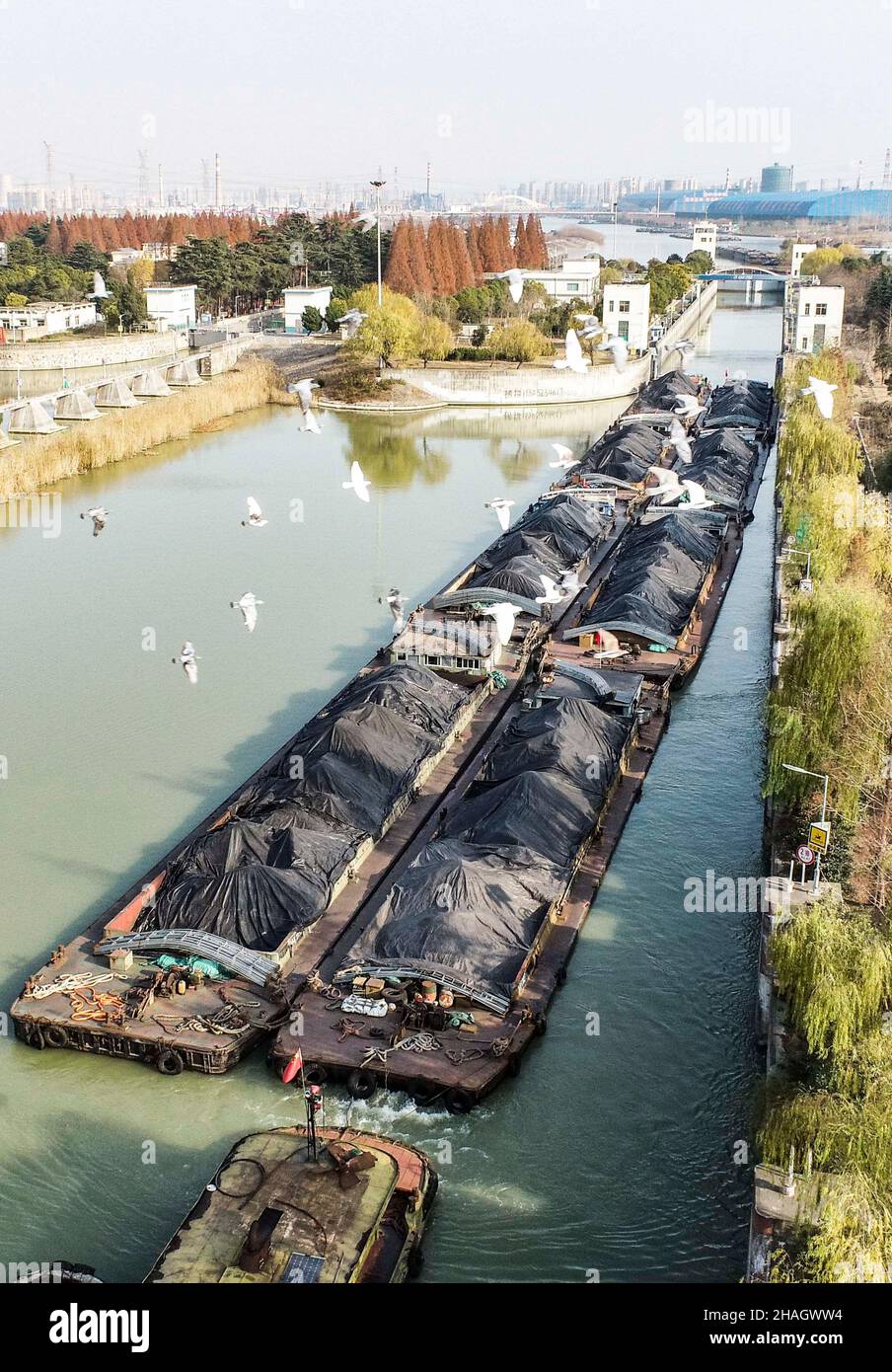 HUAIAN, CHINA - 13. DEZEMBER 2021 - Eine Flotte von Schiffen, die Kohle transportieren, durchquert die Huaiyin-Schleuse des Peking-Hangzhou Grand Canal in Huaian, Jian Stockfoto