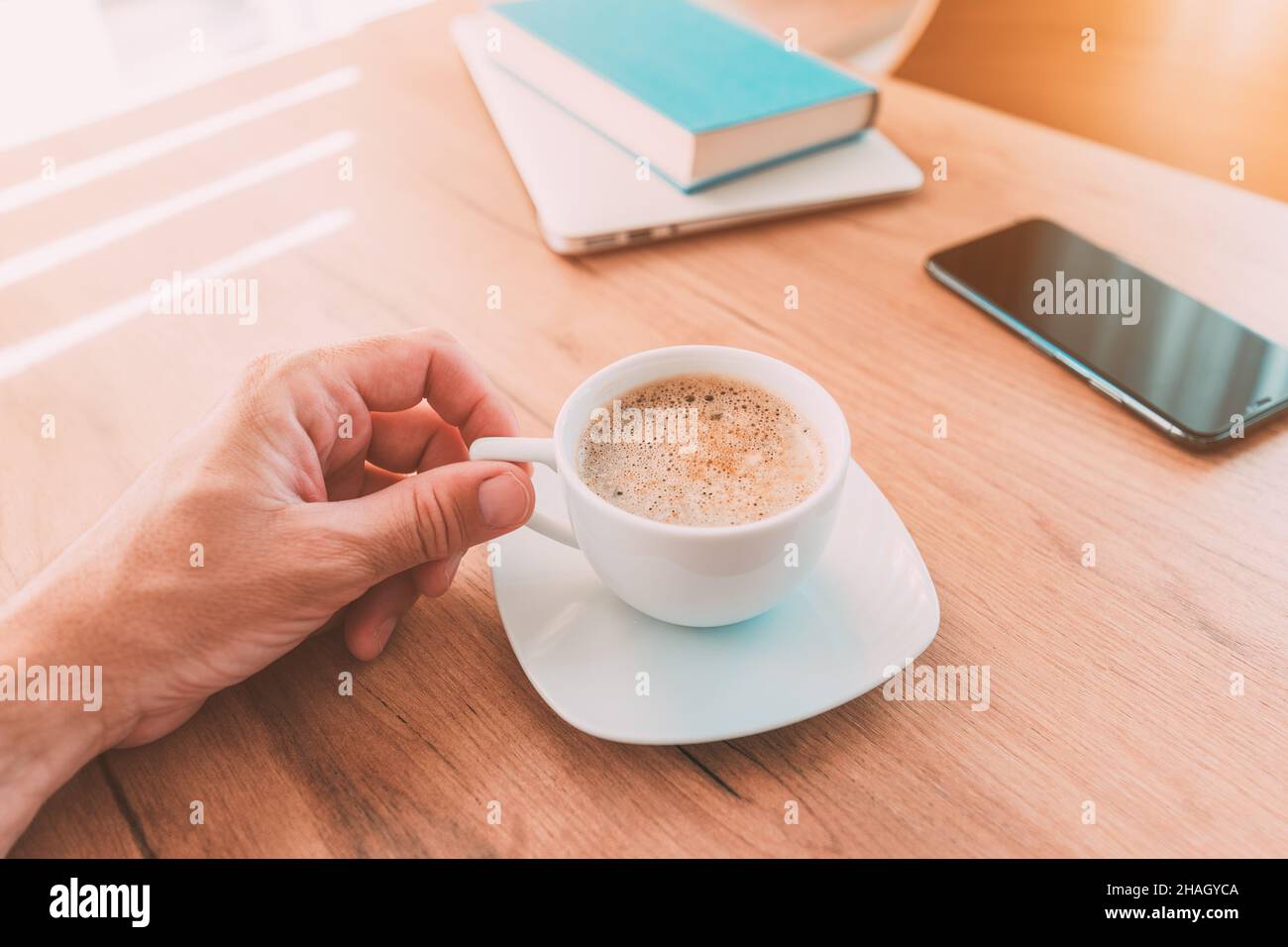 Freiberufler trinkt Kaffee zu Hause im Büro, bevor sie zur Arbeit, Hand halten Tasse, selektive Konzentration Stockfoto