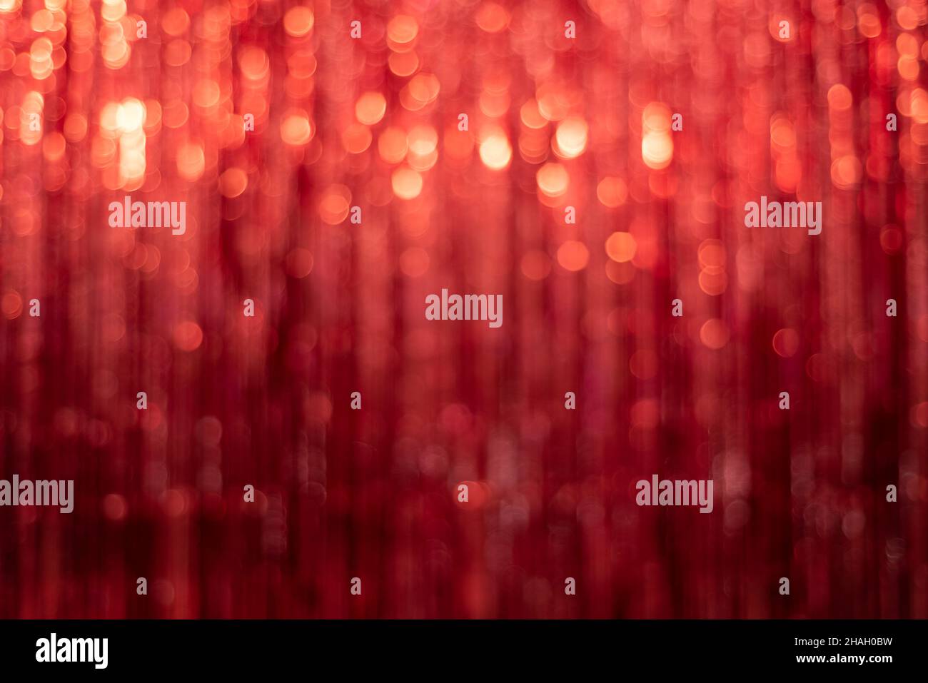 Festlicher roter Hintergrund mit Lametta unscharf und schönem Bokeh Stockfoto