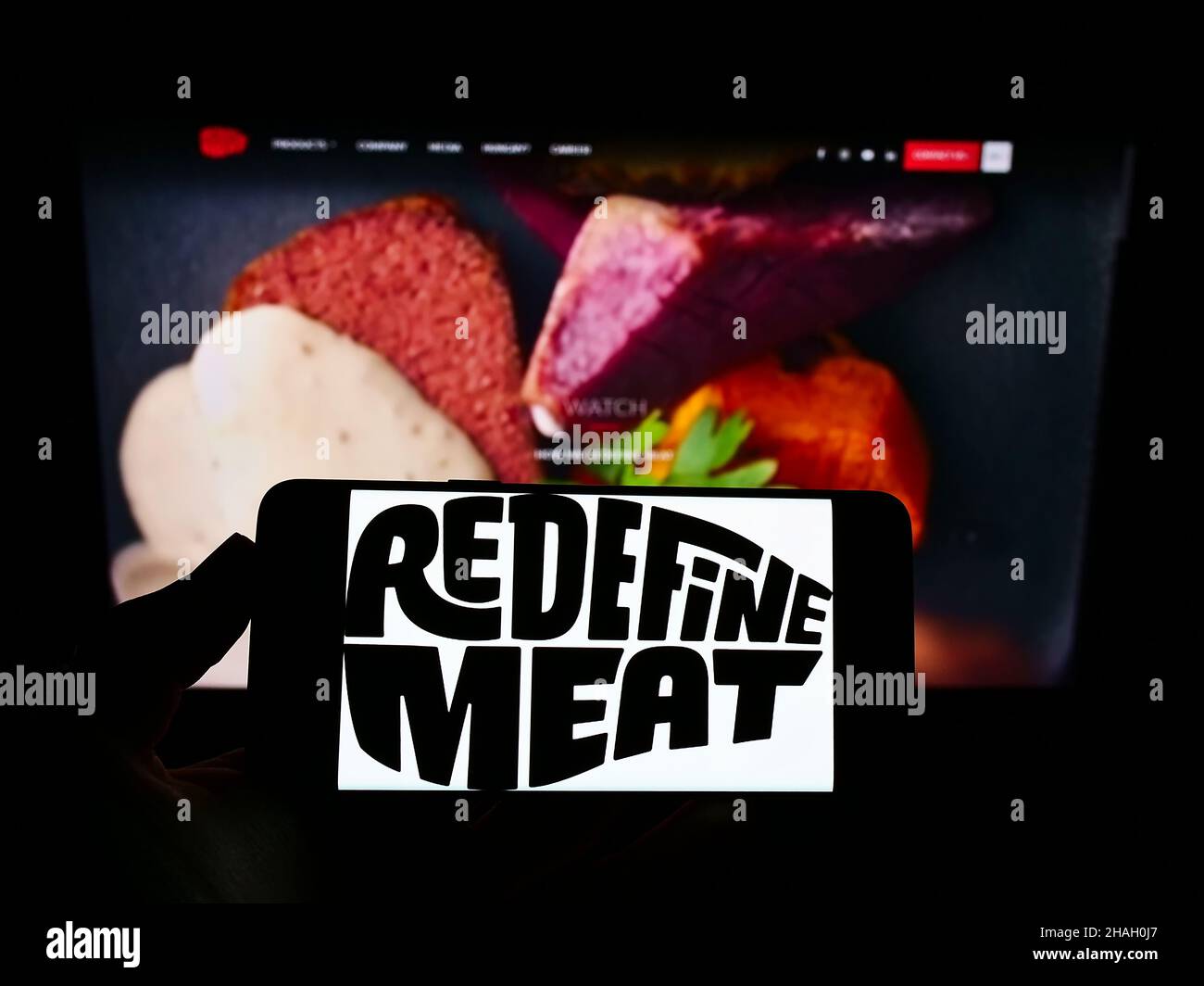 Person, die Smartphone mit dem Logo des israelischen Kulturfleischunternehmens Redefine Meat Ltd. Auf dem Bildschirm vor der Website hält. Konzentrieren Sie sich auf die Telefonanzeige. Stockfoto