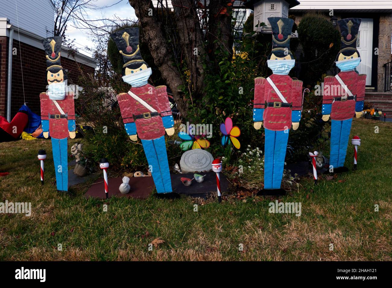 Im Zeitalter der Covid ist ein Hof mit traditionellen Nussknacker-Soldaten dekoriert, aber dieses Jahr, trägt Masken. In Queens, New York City. Stockfoto