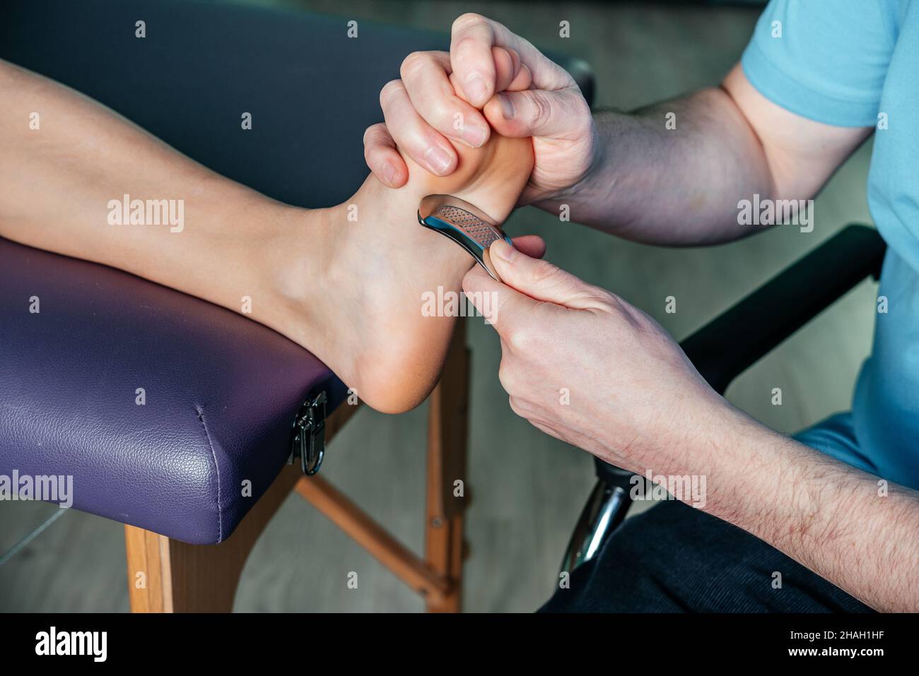 Behandlung von Schmerzen in der plantaren Ferse mit dem IASTM guasha-Tool Stockfoto