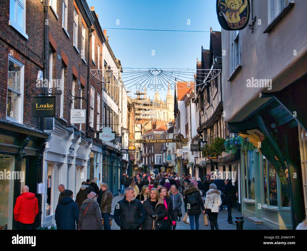 Die enge, überfüllte Einkaufsstraße von Stonegate in York, Yorkshire, Großbritannien an einem sonnigen Tag im November 2021. Stockfoto