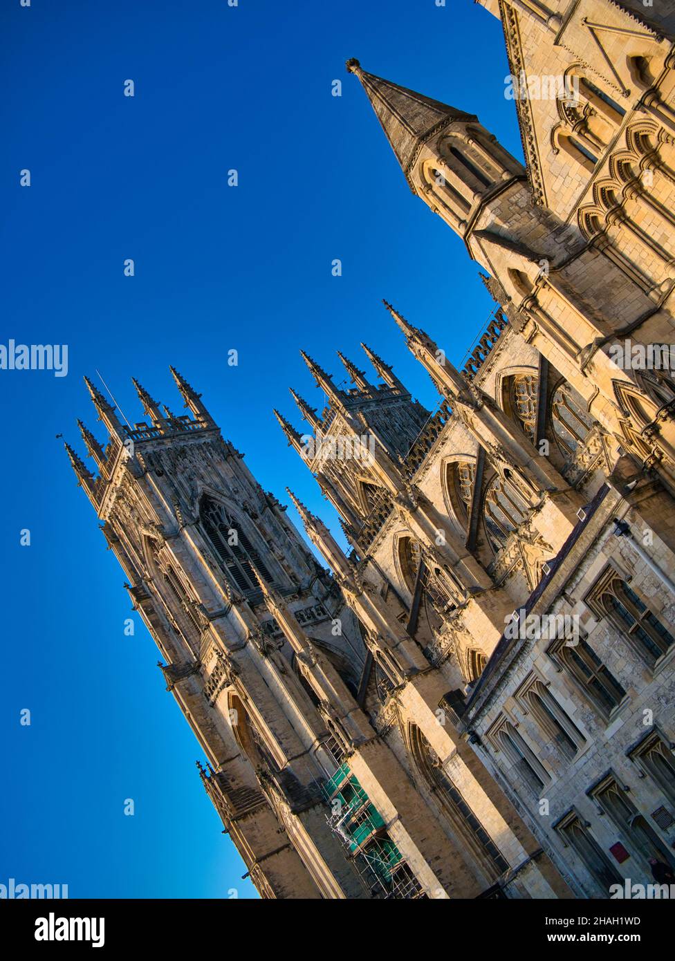 Die Türme des York Minster in der Nähe des Haupteingangs der Kathedrale - aus magnesischem Kalkstein erbaut und mit Winterabendsonne beleuchtet. Aufgenommen mit einer Neigung. Stockfoto