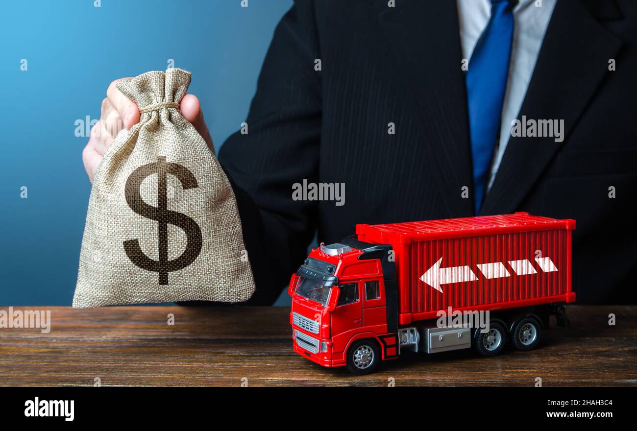 Geschäftsmann mit Geldbeutel und Lastwagen. Hohe Einnahmen aus dem Transportgeschäft und dem Güterverkehr. Gute Gehälter für Fahrer. Steigender Preis Stockfoto
