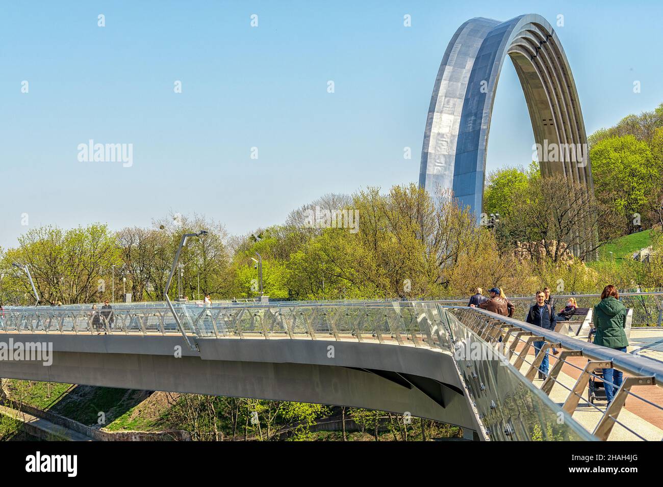 Kiew, Ukraine - 28. April 2021: Blick auf den Freundschaftsbogen und die neue Fußgängerbrücke, die mit dem Sankt-Wolodymyr-Hügel verbunden ist. Stockfoto