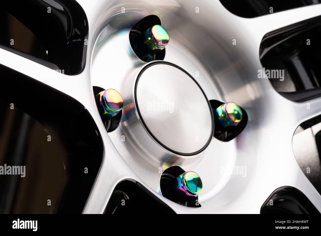 Radmontage, schöne Regenbogenmuttern auf einem glänzenden neuen Leichtmetallrad. Tuning Auto Muttern Befestigungen schimmernden Chrom. Stockfoto