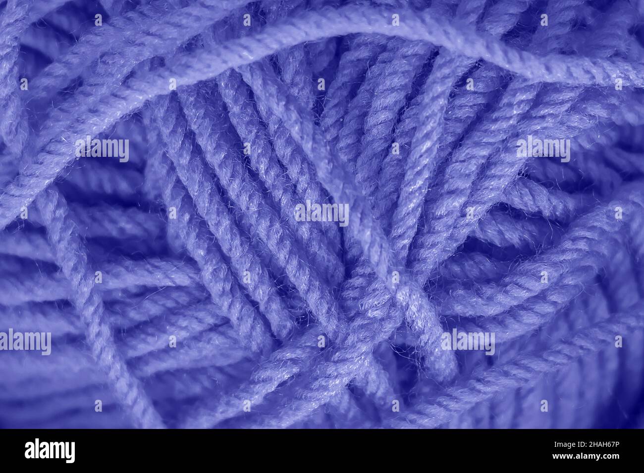 Textur aus blauen, weichen Wollfäden zum Stricken in Nahaufnahme. Trendige Farbe des Jahres 2022 Stockfoto