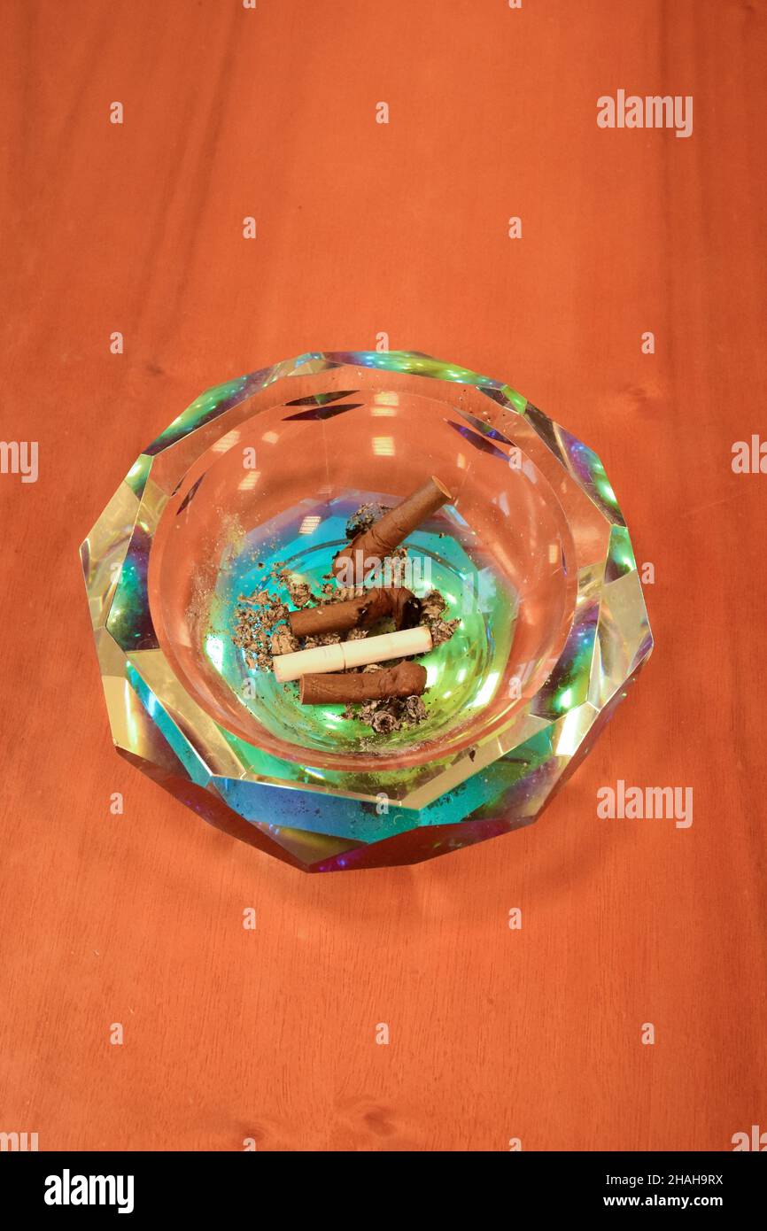 Kristallaschenbecher mit ausgestorbenen Zigarren auf einem Holztisch Stockfoto