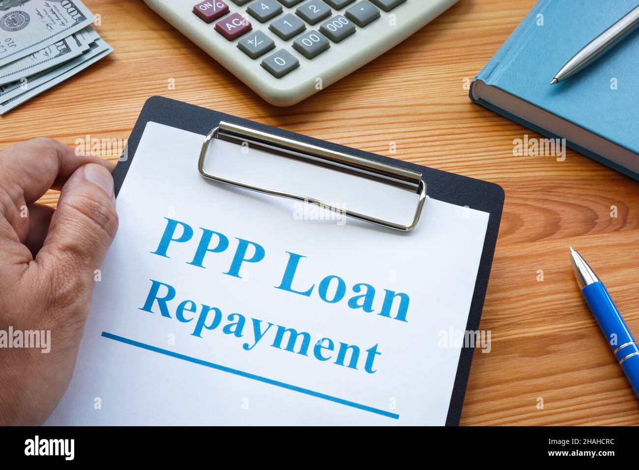 Ein Mann hält PPP Darlehen Rückzahlung Anwendung. Stockfoto