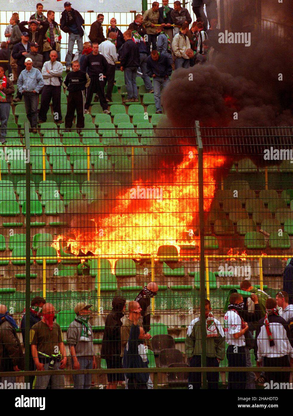 Warszawa, 09.06.2001. Podczas meczu ekstraklasy pi³karskiej w Warszawie miêdzy sto³eczn¹ Legi¹ a Wis³¹ Kraków dosz³o do ekscesów na trybunach. N/z: p³on¹ce krzes³a w sektorze kibiców Legii. (kruu) PAP/Przemek Wierzchowski Warschau, 09.06.2001. Der Brand im Legia Warsaw Stadion war nach Zusammenstößen zwischen der Polizei, den Anhängern von Wisla Krakau und Legia Warsaw während eines Fußballligaspieles am Boden zerstört. (kruu) PAP/Przemek Wierzchowski (kruu) PAP/Przemek Wierzchowski Stockfoto