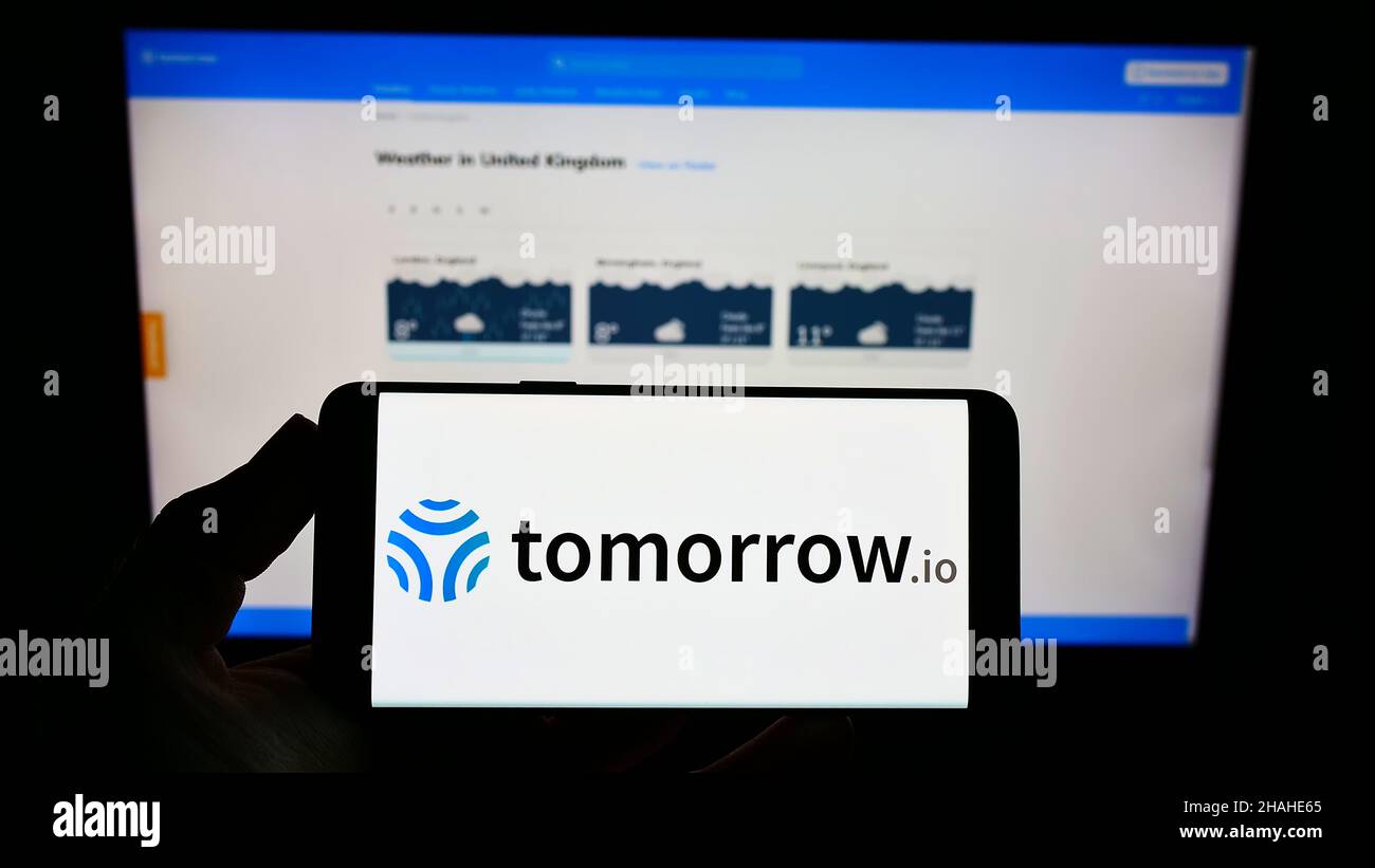 Person, die das Smartphone mit dem Logo der Firma The Tomorrow Companies Inc. (Tomorrow.io) auf dem Bildschirm vor der Website hält. Konzentrieren Sie sich auf die Telefonanzeige. Stockfoto