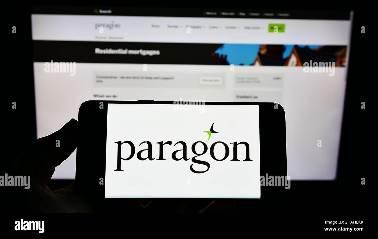 Person, die ein Smartphone mit dem Logo des britischen Finanzunternehmens Paragon Banking Group plc auf dem Bildschirm vor der Website hält. Konzentrieren Sie sich auf die Telefonanzeige. Stockfoto