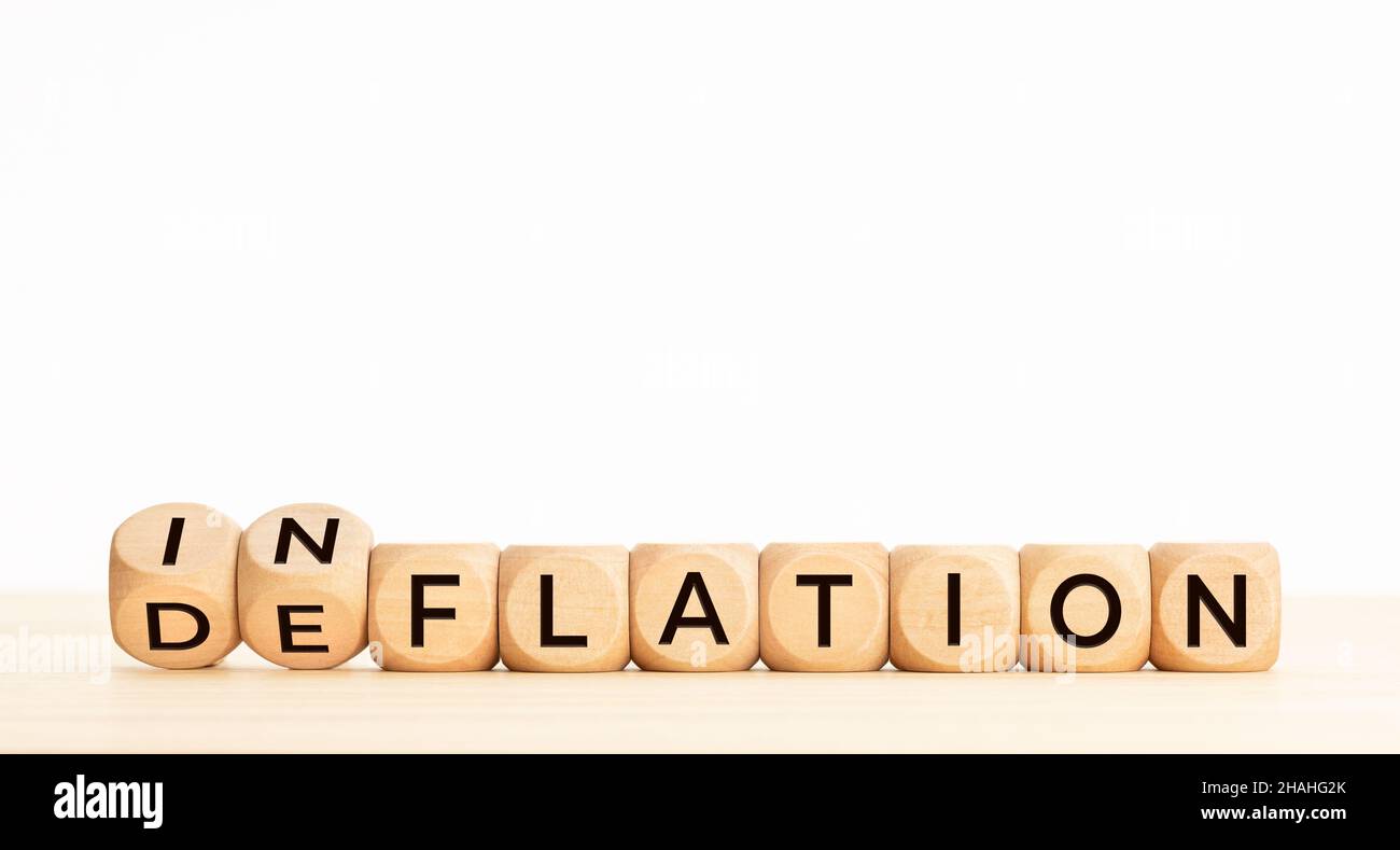 Wort „Inflation“ oder „Deflation“ in Holzblöcken auf dem Tisch. Speicherplatz kopieren Stockfoto