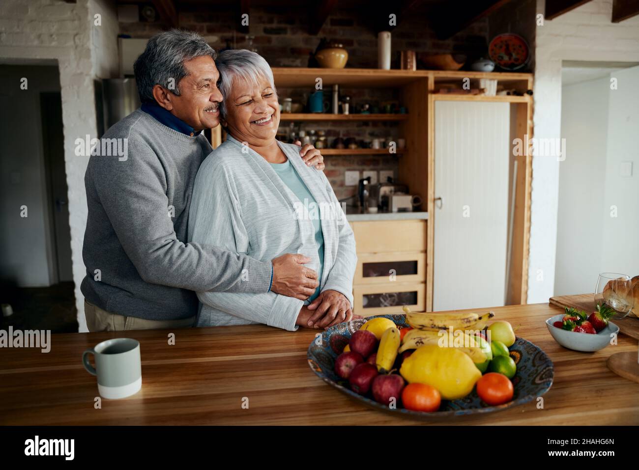Glücklich Rentner ältere biracial Paar stehend, umarmt. Gesunder Lebensstil in der modernen Küche. Stockfoto