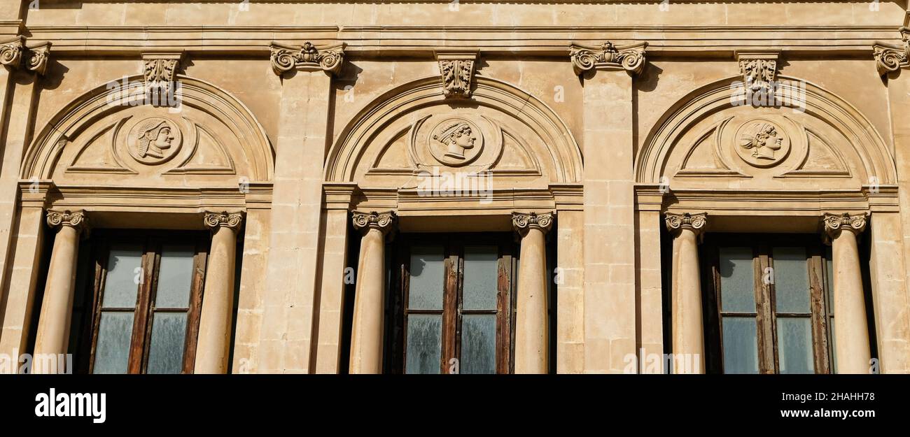 Ortigia, Syrakus. Sizilien. Seminario Vecchio Fassade teilweise Ansicht, mit mehreren Profilen in niedrigem Relief, basierend auf alten griechischen Münzen. Stockfoto