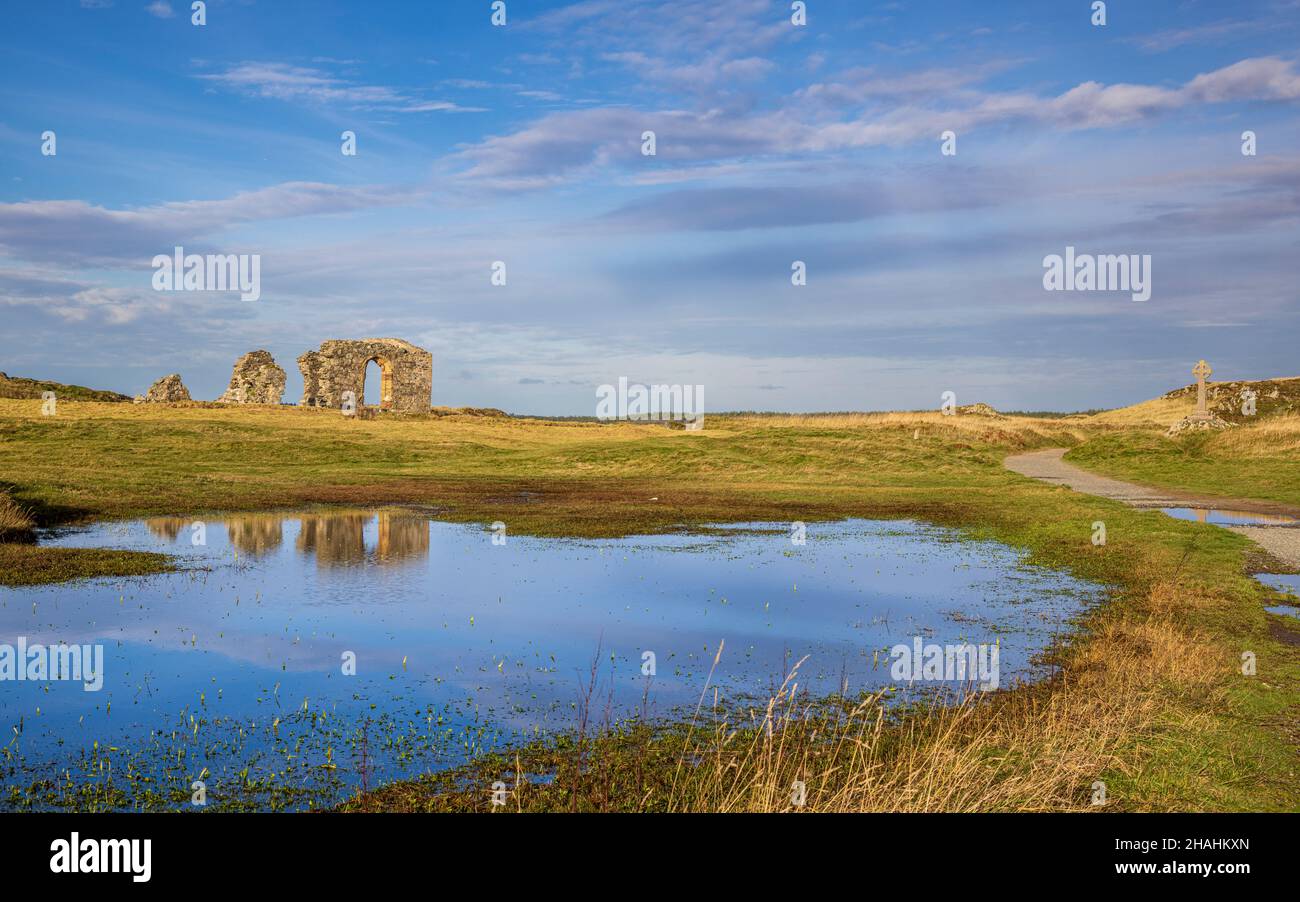 Die Ruinen der St. Dwynwen Kirche spiegeln sich im Wasser auf Llanddwyn Island, Isle of Anglesey, Nordwales Stockfoto