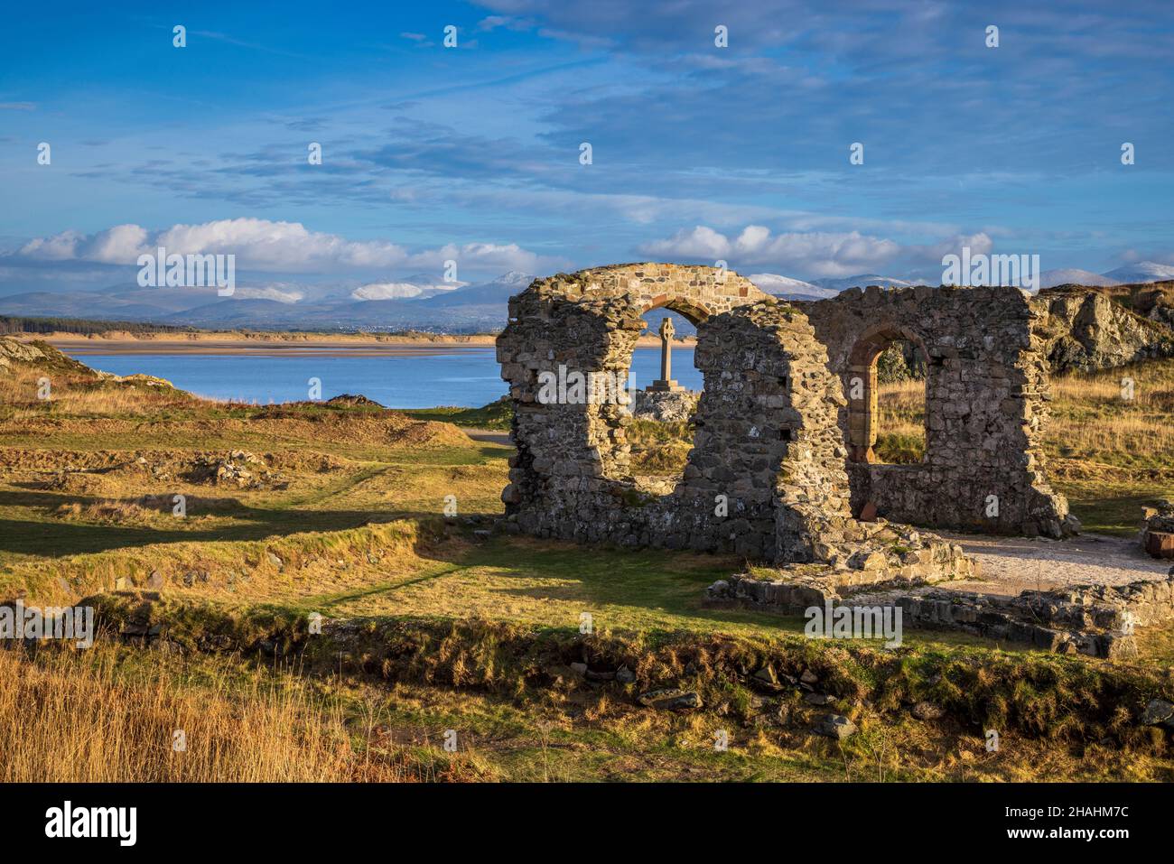 Das keltische Kreuz und die Ruinen der St. Dwynwen-Kirche auf der Insel Llanddwyn, Isle of Anglesey, Nordwales Stockfoto
