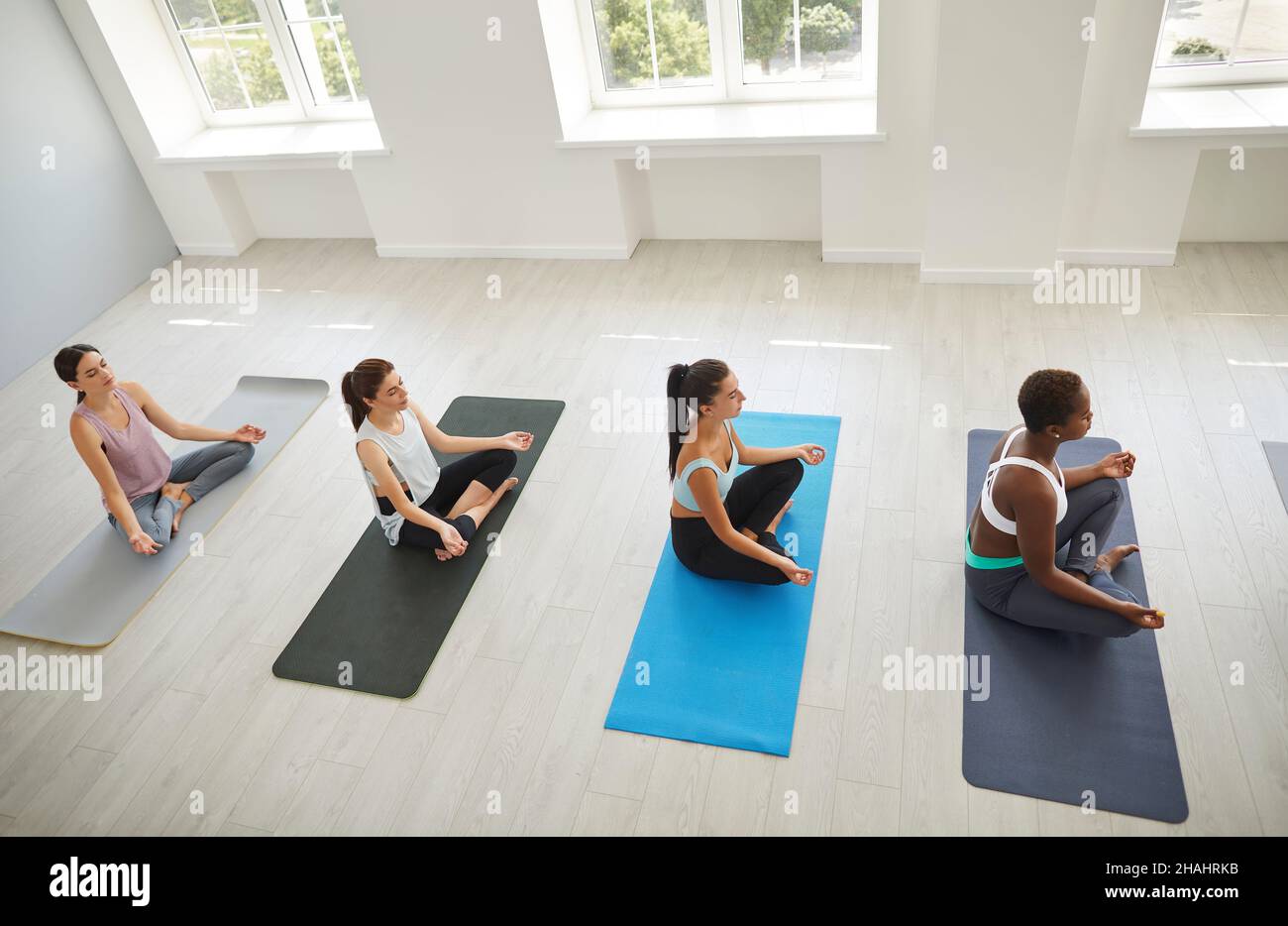 Verschiedene Frauen praktizieren Yoga und meditieren gemeinsam Stockfoto