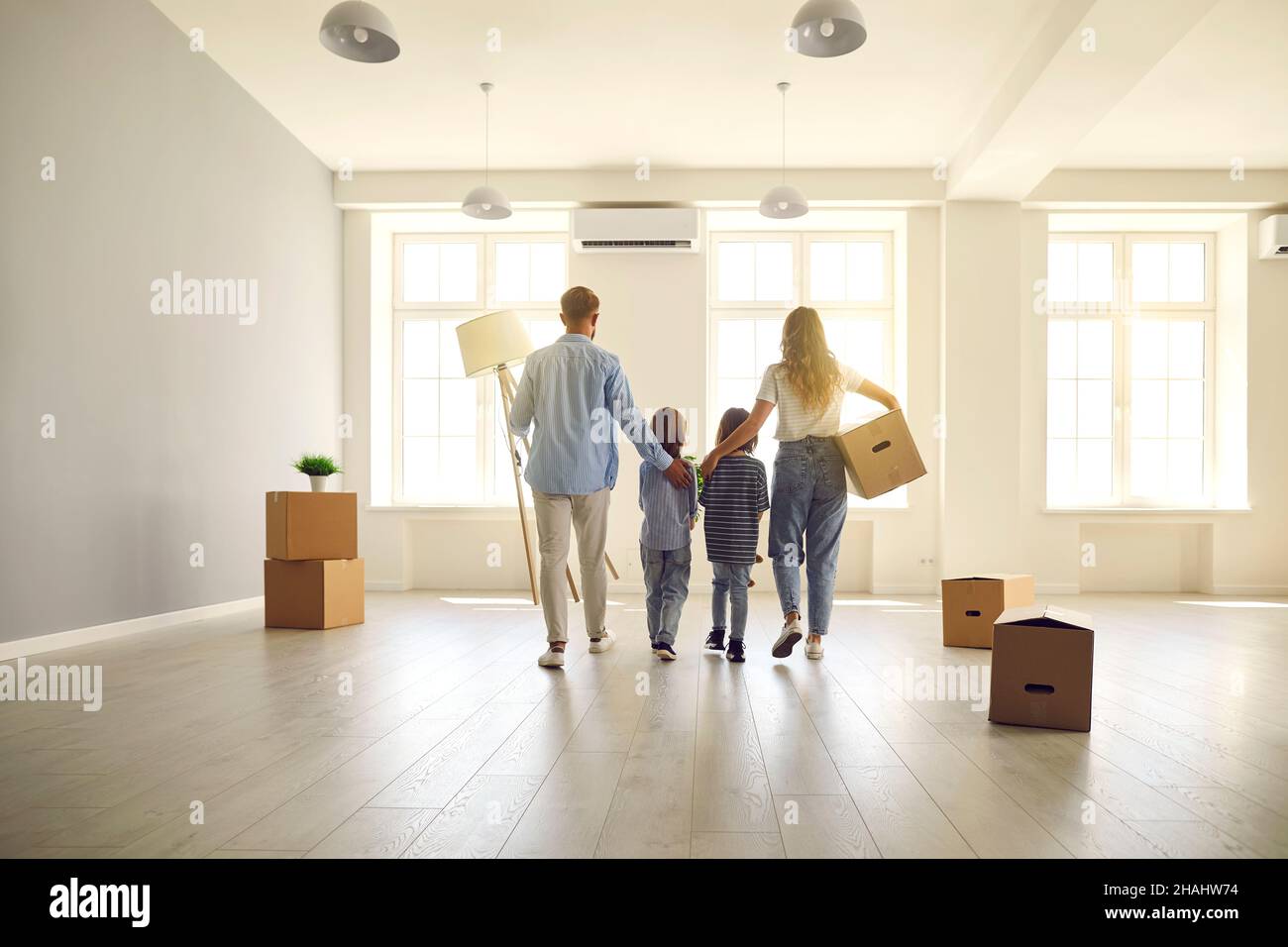 Familie mit Kindern am Tag der Bewegung Spaziergänge in Zukunft Wohnzimmer in ihrem neuen Zuhause. Stockfoto