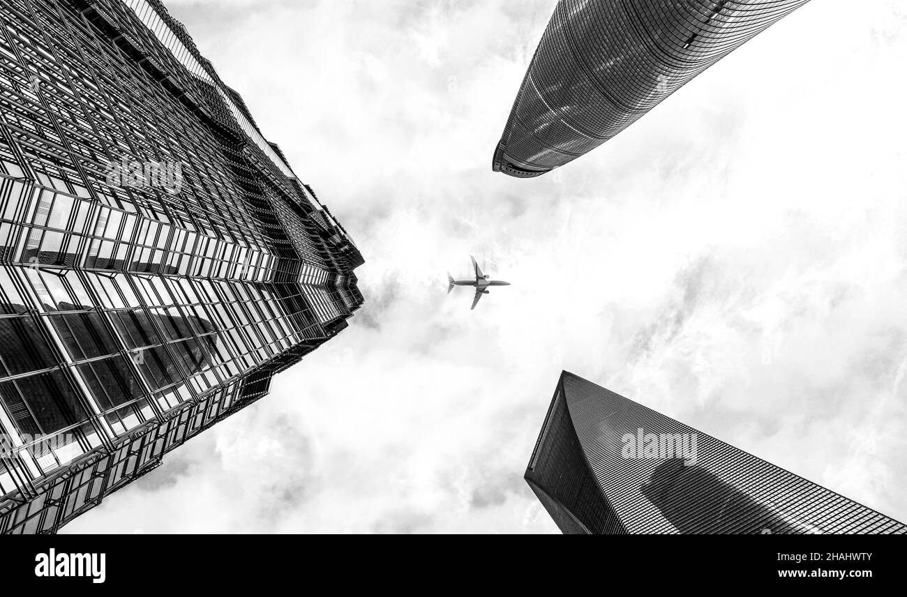 Schwarz-Weiß-Planaufnahme, die über den modernen Wolkenkratzern von Shanghai fliegt Stockfoto