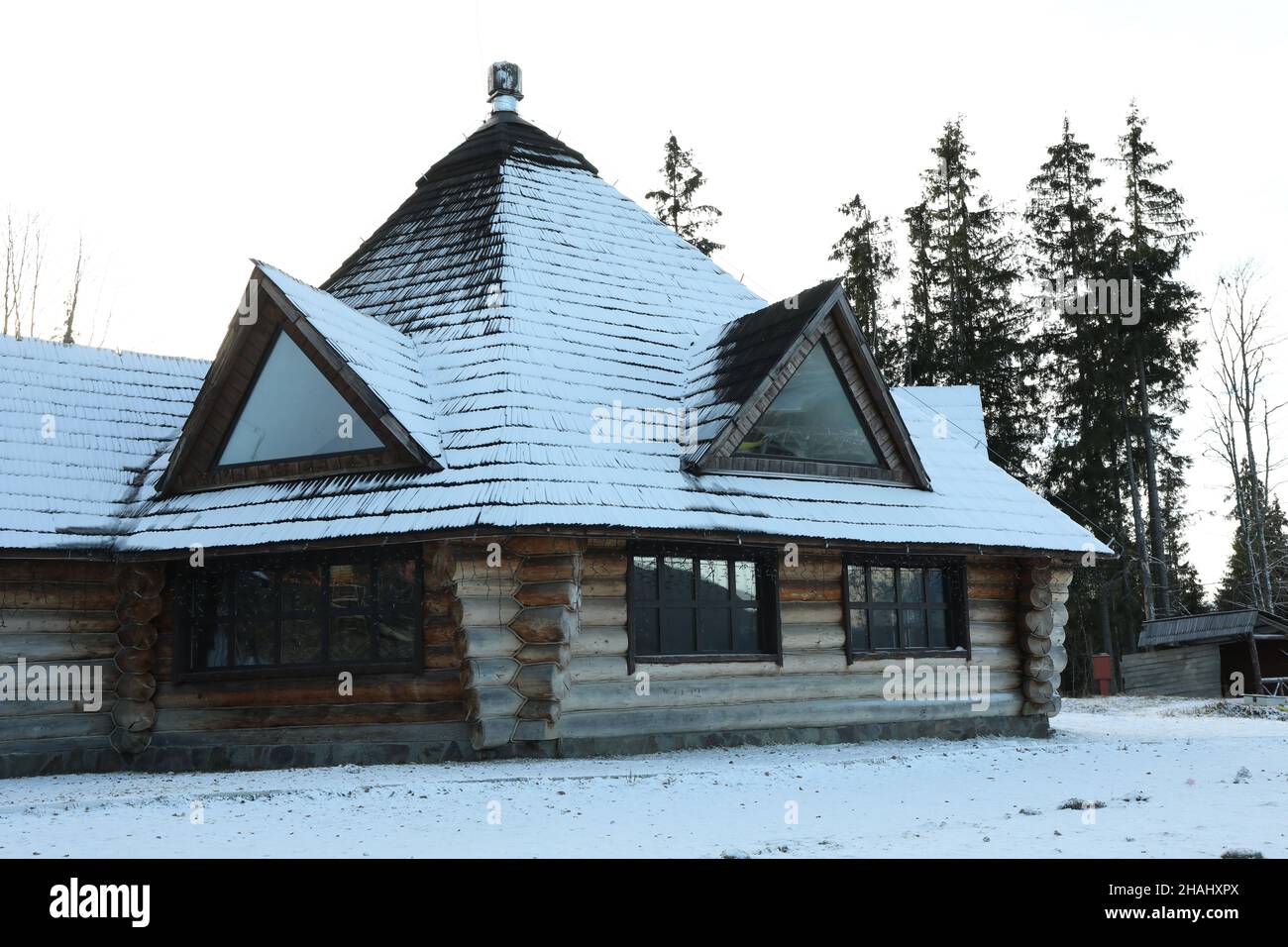 Gemütliches Holzhaus mit Schnee am Wintertag Stockfoto
