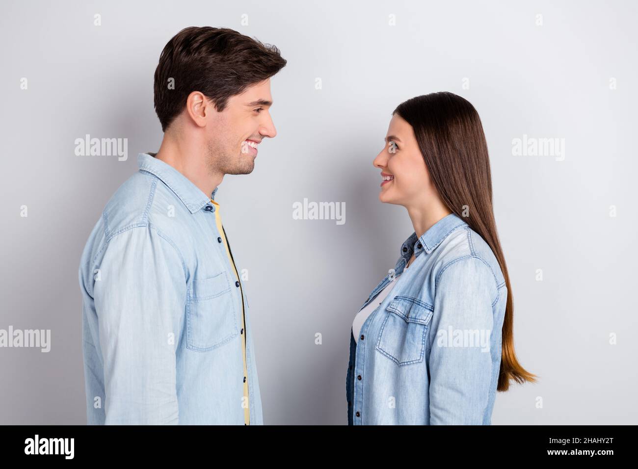 Foto von niedlichen hübschen Schwester Bruder gekleidet Denim Hemden Blick Augen lächelnd isoliert grauen Hintergrund Stockfoto