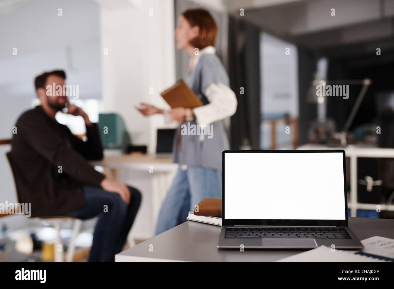 Nahaufnahme der Arbeitswelt eines Geschäftsreisenden mit Laptop für Online-Arbeiten im Büro mit Geschäftsleuten im Hintergrund Stockfoto