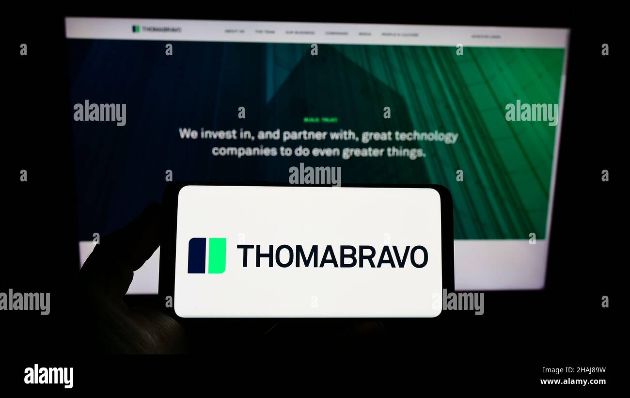 Person, die ein Smartphone mit dem Logo des US-amerikanischen Private-Equity-Unternehmens Thoma Bravo L.P. auf dem Bildschirm vor der Website hält. Konzentrieren Sie sich auf die Telefonanzeige. Stockfoto