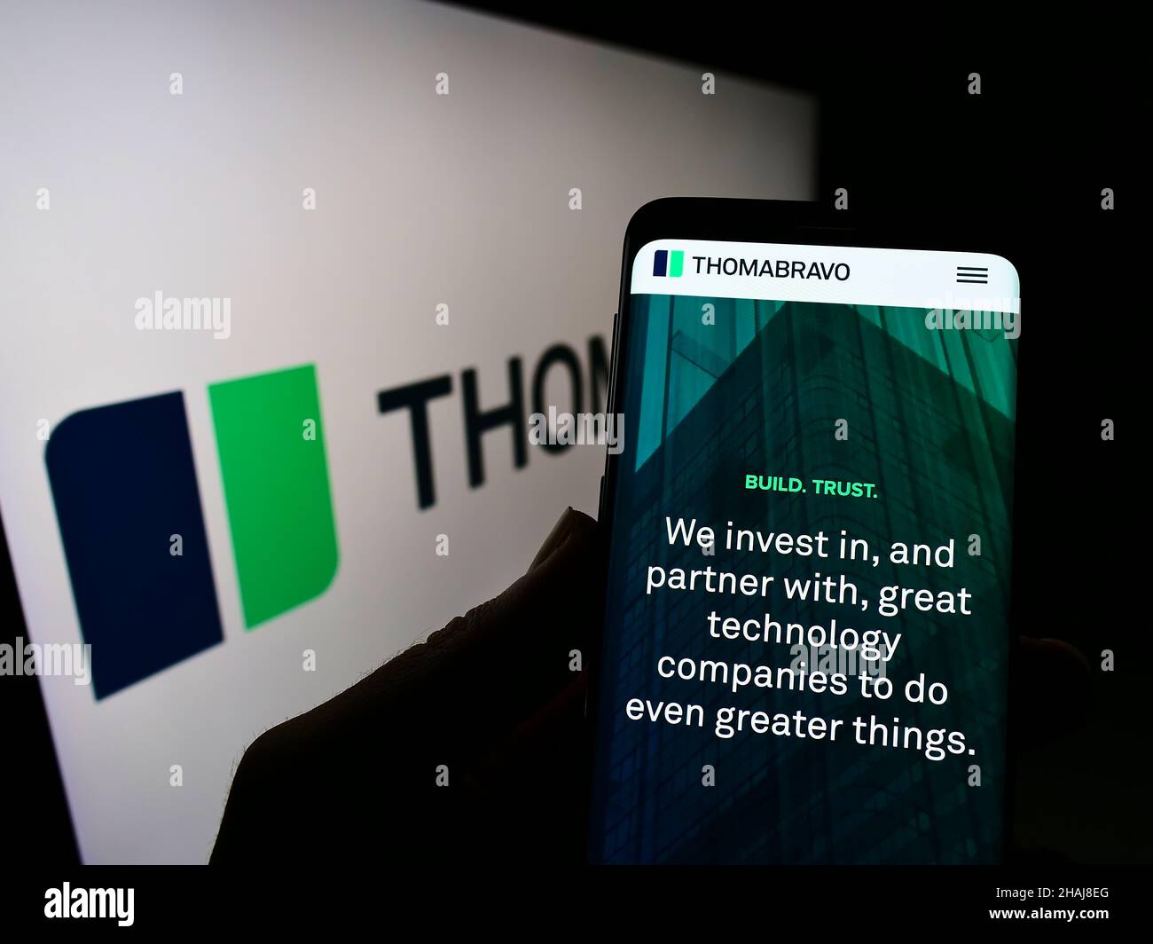 Person, die Mobiltelefon mit der Webseite des US-amerikanischen Private-Equity-Unternehmens Thoma Bravo L.P. auf dem Bildschirm vor dem Logo hält. Konzentrieren Sie sich auf die Mitte des Telefondisplays. Stockfoto