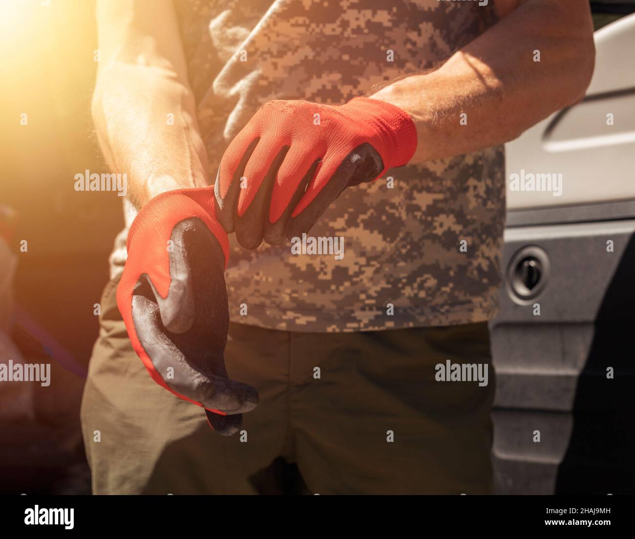 Nahaufnahme der Hände des Kfz-Mechanikers oder Reparaturers, die Handschuhe anziehen. Stockfoto