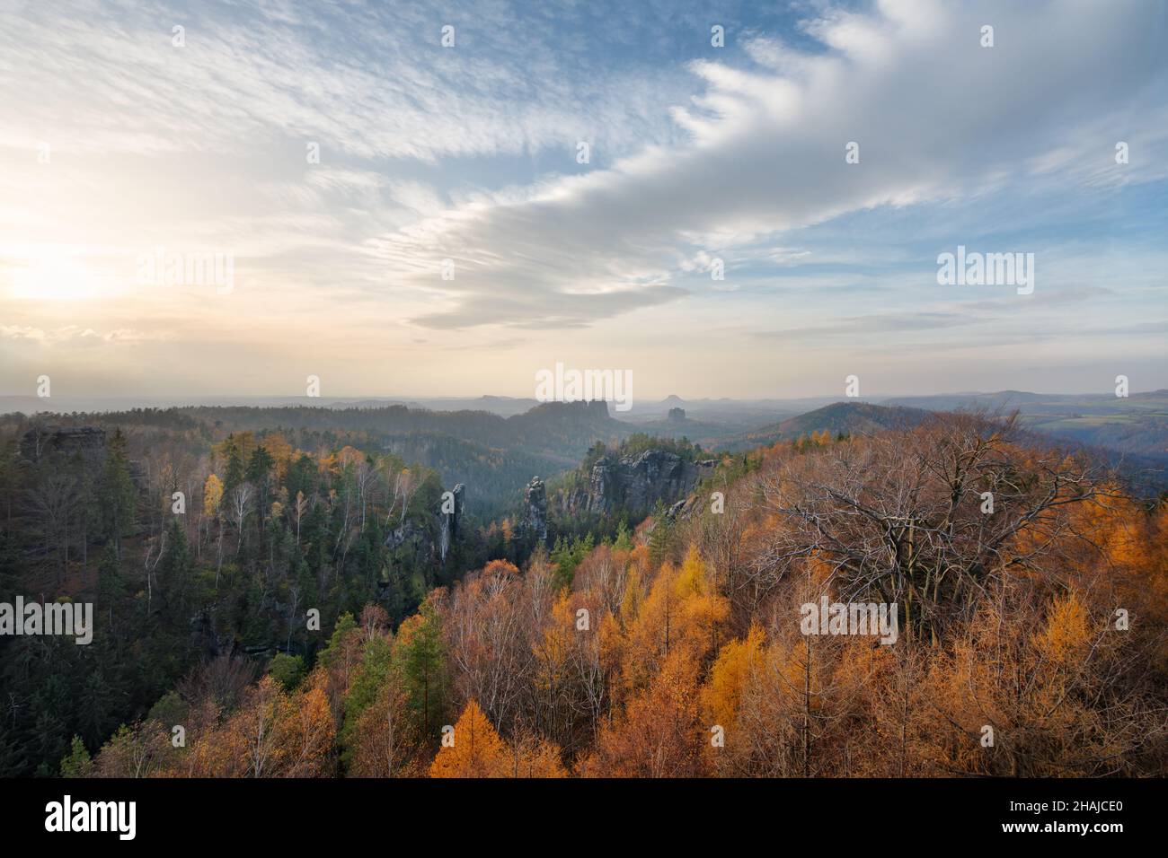 Elbsandsteingebirge - Blick auf beeindruckende Felsformationen und weite Landschaft mit Hintergrundbeleuchtung, Bäume in hellen Herbstfarben, Abendlicht mit hellem Klo Stockfoto